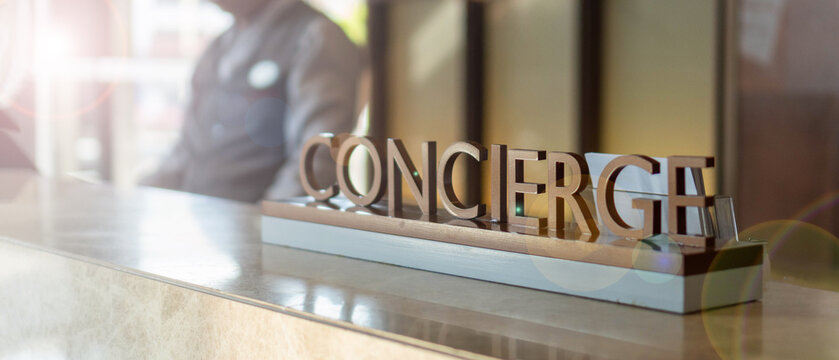 Concierge service desk counter with staff team working in front of hotel with tourist business customer.