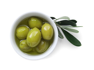 Delicious marinated green olives in bowl and leaves isolated on white, top view