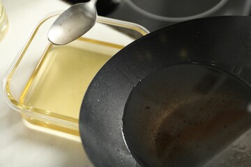 Pouring used cooking oil at white countertop, closeup