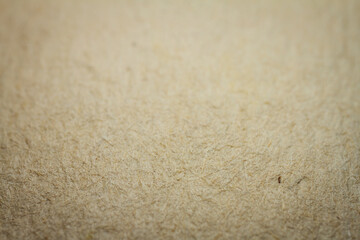 Extreme closeup of beige handmade paper with shallow depth of field.