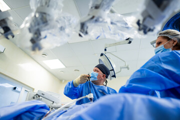 Surgery performed in OR. A surgical team is focused while performing an operation, ensuring...