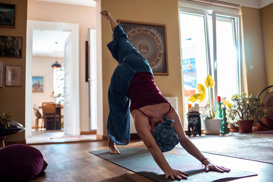 Woman meditating indoors with headscarf practicing yoga at home