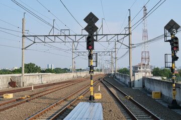 Fototapeta premium Railway Tracks with Red Traffic Signals and Overhead Power Lines