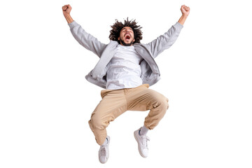 Cheerful man in grey jacket and beige pants jumping high with arms up, expressing happiness and excitement, wearing casual white sneakers, isolated on transparent background