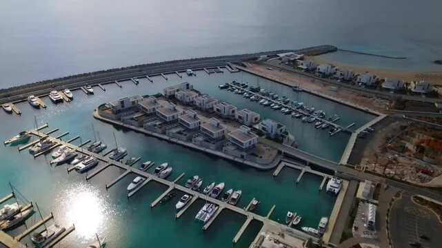 Ayia Napa Cyprus. Bird's eye view of Ayia Napa Marina.
High-rise building and marina on a sunny day. Mediterranean Sea and modern architecture. Nature and urbanism against the backdrop of the sea.