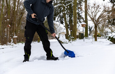 Schnee von Hand mit der einer Schneeschaufel räumen