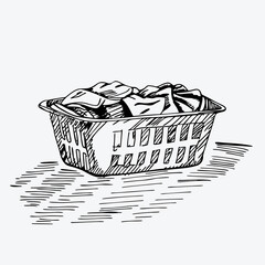 Obraz premium Hand-drawn laundry basket with grid pattern sides containing crumpled clothes. Sketch includes shading beneath basket. Concept: home organization, laundry service