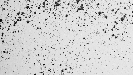 gray background, photograph of black paint splashes on white wall