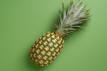 Fresh pineapple on vibrant green background, showcasing its unique texture and color. This tropical fruit adds refreshing touch to any setting