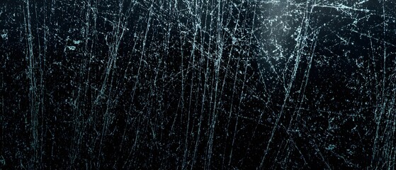 High detail macro view of a black glass surface showing dust particles and prominent scratches