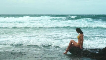 Sexy woman in bikini swimsuit standing on beach at the ocean waves. Vacation, traveling, relaxation concept. Sexy woman ocean water, freedom and life an beautiful beach. Vacations at summer sea beach.