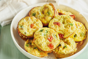 Delicious vegetarian egg muffins with tomatoes , cheddar cheese, and green bell peppers.  Selective...