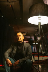 Obraz premium A man poses confidently in a chic, modern setting with aesthetic lighting. Perfect for lifestyle content.