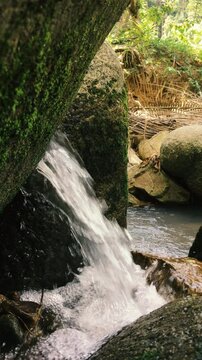 A stream of water flowing on rocks in the middle of the jungle