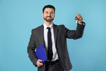 Cheerful salesman with car key and clipboard on light blue background