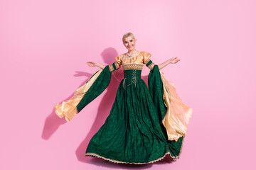 Fototapeta premium Elegant woman in medieval-style attire posing with grace against a vibrant pink background