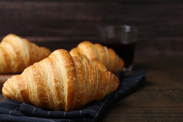 Tasty fresh croissants on wooden table, closeup. Space for text