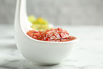 Sauce boats with salsa on white marble table, selective focus