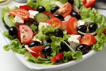 Delicious fresh Greek salad on white table, closeup