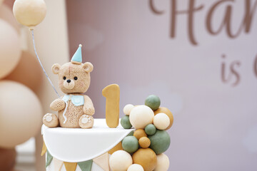 A charming teddy bear-themed first birthday cake with intricate fondant decorations, pastel colors,...