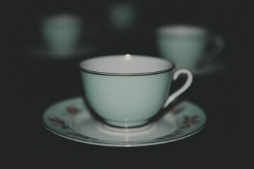 A cup with a floral design sits on a white plate