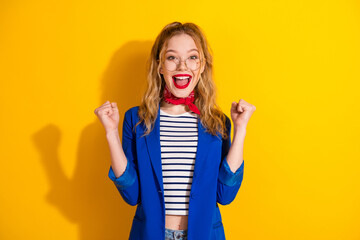 Charming young woman in stylish outfit smiling joyfully against vibrant yellow background