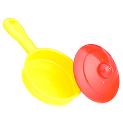 A set of children's toy dishes isolated on a white background. Plastic frying pan, lid and spatula. Children's kitchen. Educational role-playing games for children