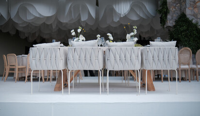 Linen chairs, ceiling design, and floral table design at luxury wedding