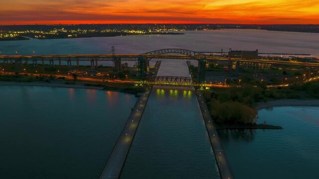 Sunset over the Soo Locks, a freighter transits the waterway.