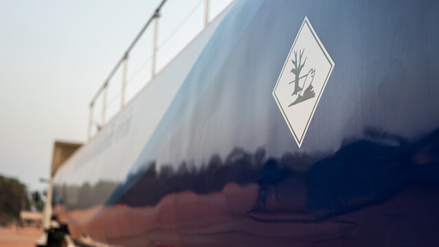 Enviromental impact placard sign of dealth biology picture, that installaed on the storage tank of the chemical road tanker vehicle. Safety sign and symbol for transportation. Selective focus.