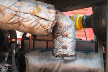 Close-up at thermal insulation material that wrapping on the machine pipeline. Industrail equipment...