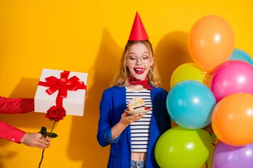 Gordijnen Charming young woman in stylish outfit celebrating with balloons on yellow background © deagreez
