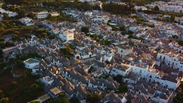 Aerial view of characteristic trulli houses at sunset in Alberobello, tourist town in Puglia, Italy