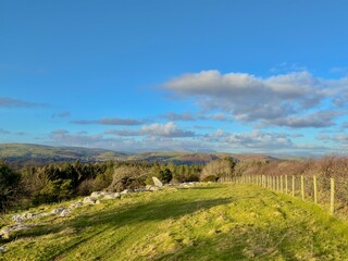 Fototapeta premium A view of rolling hills and lush countryside under a vast blue sky