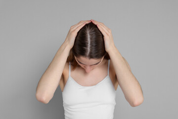 Girl with hair loss problem on grey background