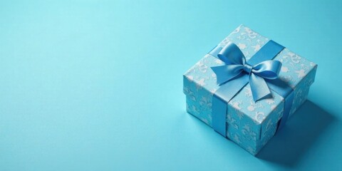 A single light blue gift box with a light blue ribbon bow sits on a matching background