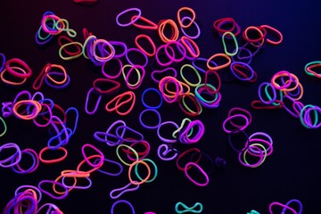 Neon Rubber Bands Scattered on Dark Background