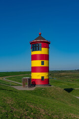 Der gelb-rote Leuchtturm auf dem Deich