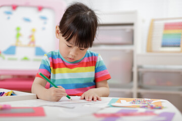 Young girl studying various geometric shapes by sketching them at home