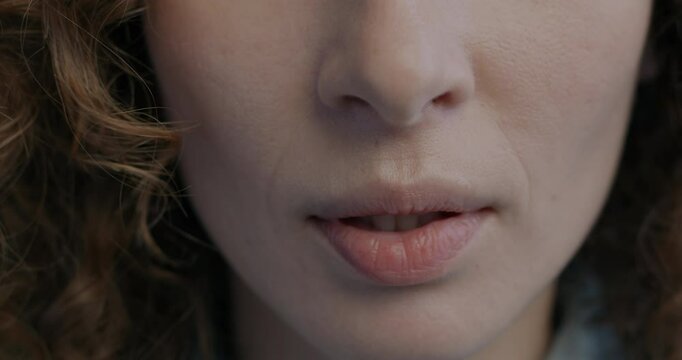 Close-up of female mouth while nervous anonymous woman biting and pursing lips feeling insecure and hurt. People and negative emotion concept.