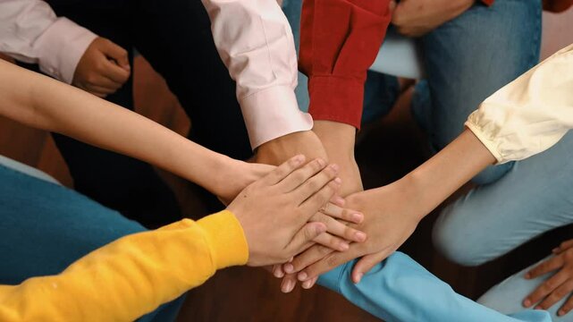 Panoramic video happy asian startup company employee wearing colorful casual cloth sit around together stack hand together symbol good teamwork, harmony team, positive environment workplace. Synergic
