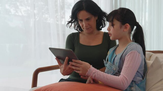 Granddaughter guide grandmother how to use touch screen control tablet. Senior adapt to technology activity communicate new generation kid cross generation gap strengthen family bond. Divergence.