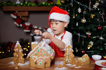 little girl decorating ginger bread House for celebrating Christmas at home