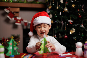 young girl making Christmas craft at home for celebrating Christmas