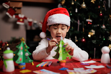 young girl making Christmas craft at home for celebrating Christmas