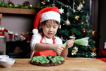 little girl decorating cup cake for celebreating Christmas at home