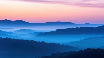 Obraz premium A serene landscape showcasing rolling hills shrouded in mist at dawn, with a pastel sky blending soft pinks and blues.