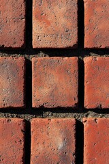 A detailed shot of a red brick wall with textured surface and subtle color variations