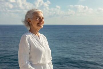 Fototapeta premium A woman stands by the ocean, looking out at the sea