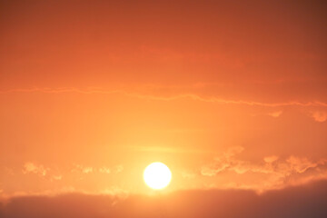 Sunset Serenade: A breathtaking view of a vibrant orange sunset, the sun a radiant orb nestled...